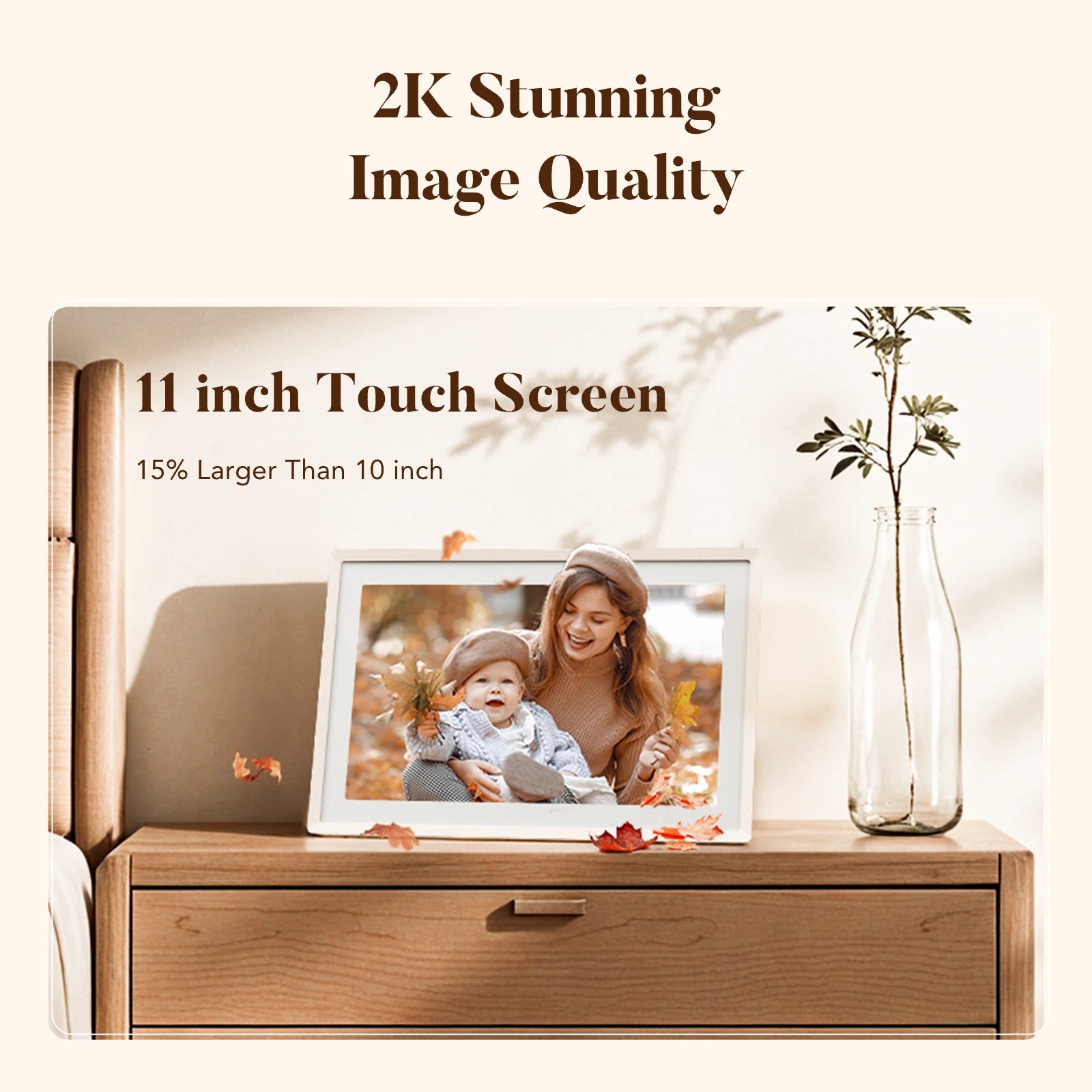 Sand 2K digital picture frame with 11-inch touch screen on a nightstand showing a mother and baby among autumn leaves