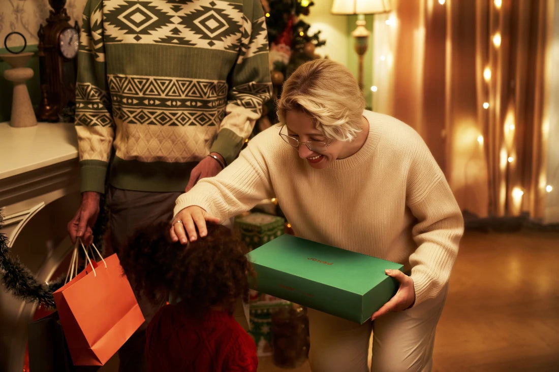 Woman receiving a green gift box contains pexar digital picture frame from a child as Christmas gift.