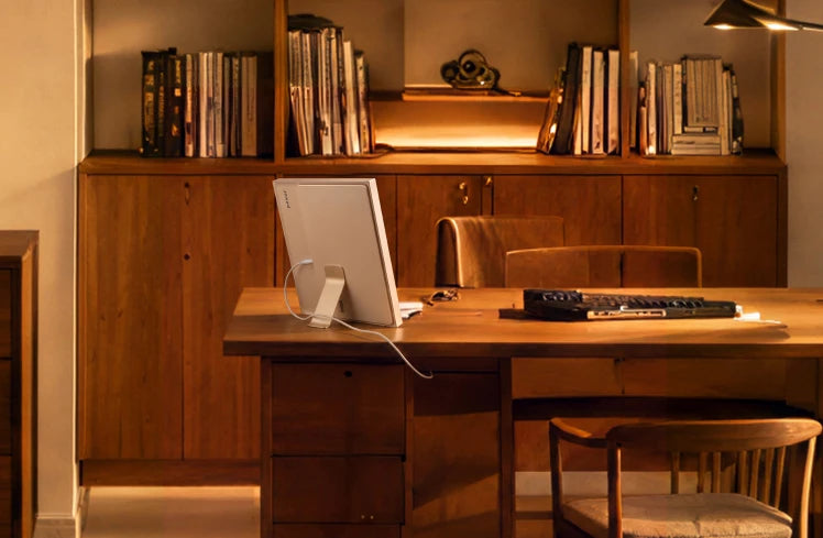 Frame on a desk below a lit bookshelf